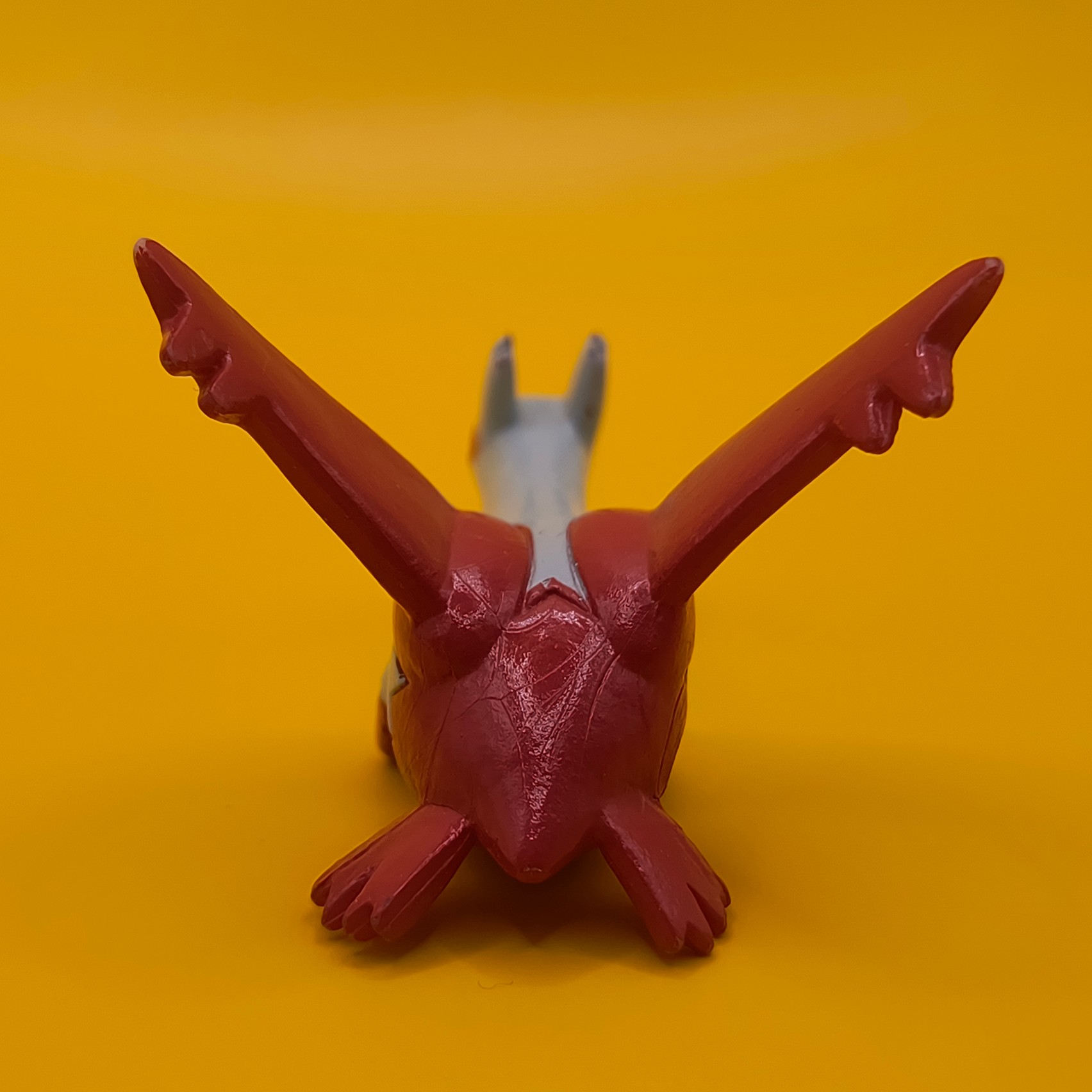 Rød og hvid Latias Pokémon-figur fra Bandai med stempler på vingerne.