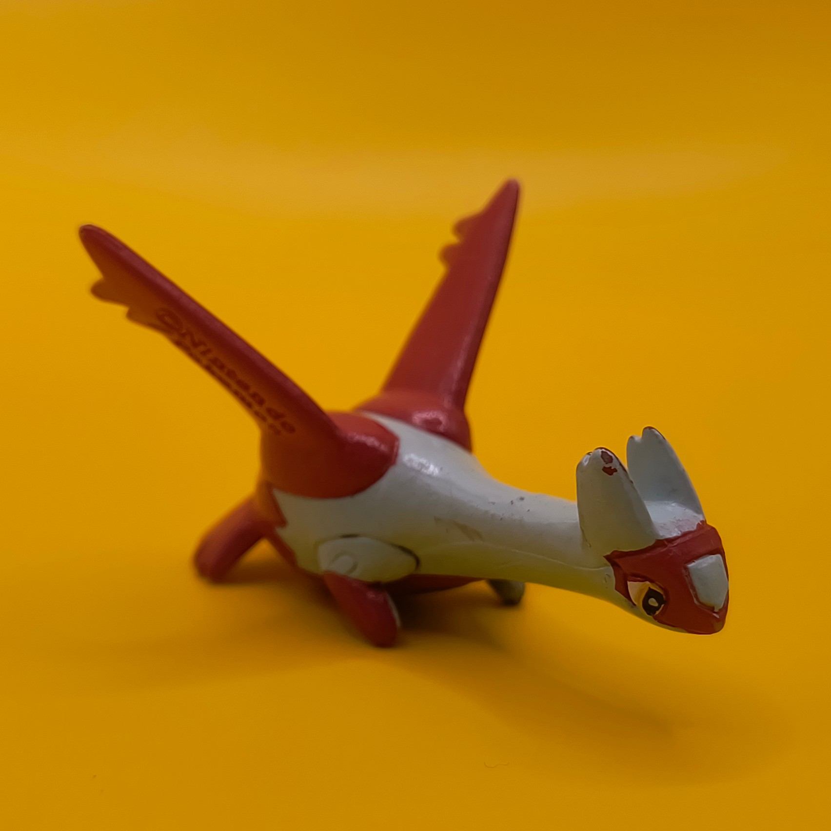 Rød og hvid Latias Pokémon-figur fra Bandai med stempler på vingerne.