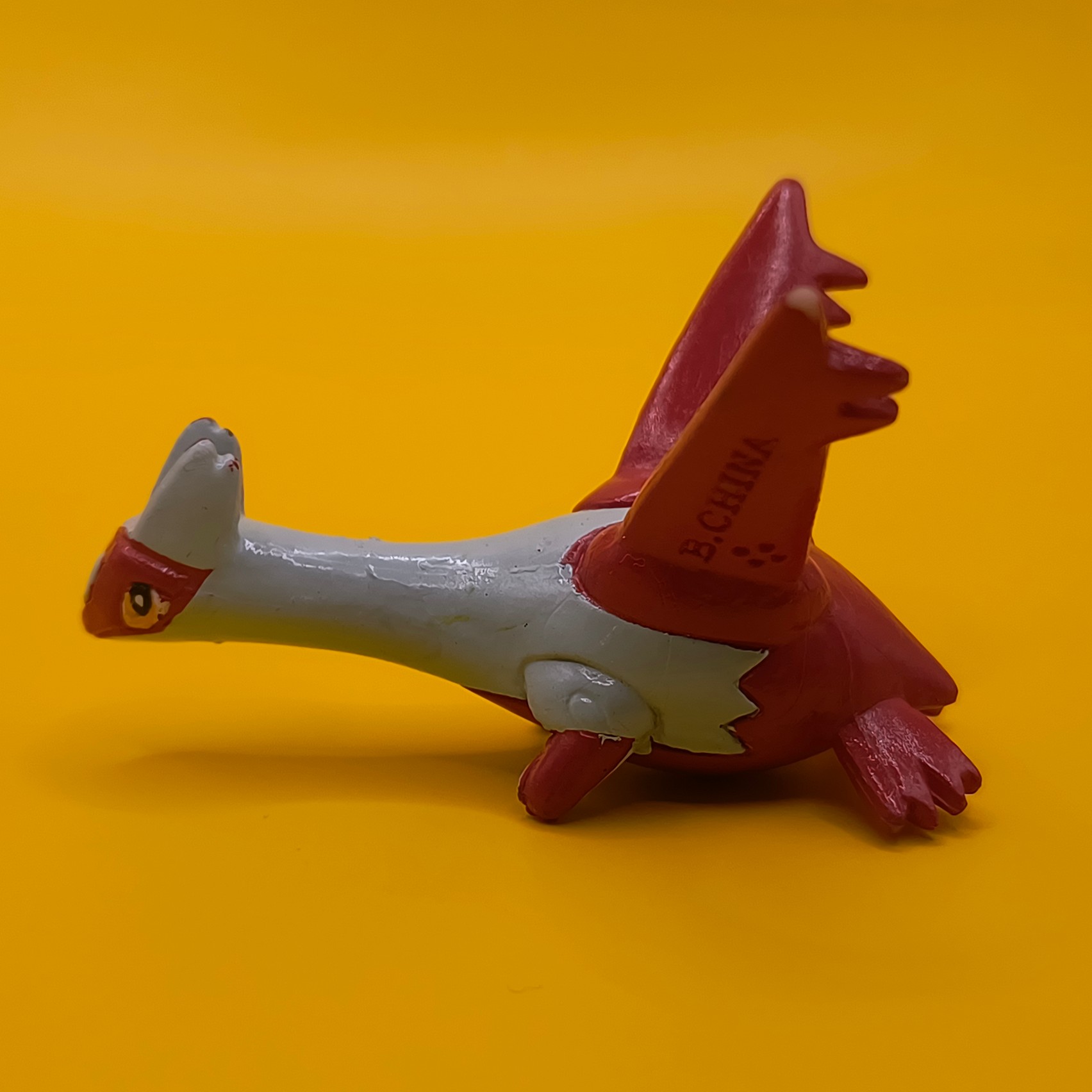 Rød og hvid Latias Pokémon-figur fra Bandai med stempler på vingerne.