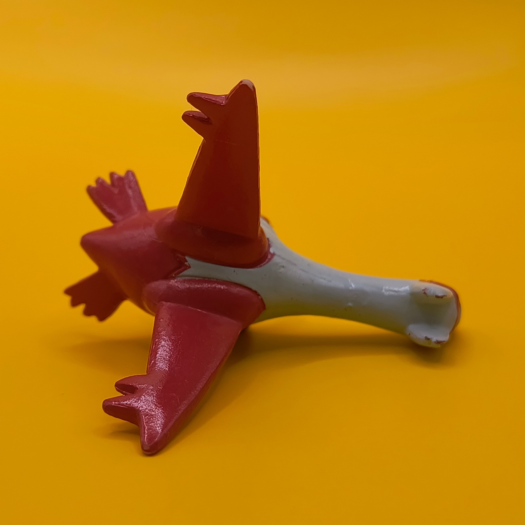 Rød og hvid Latias Pokémon-figur fra Bandai med stempler på vingerne.