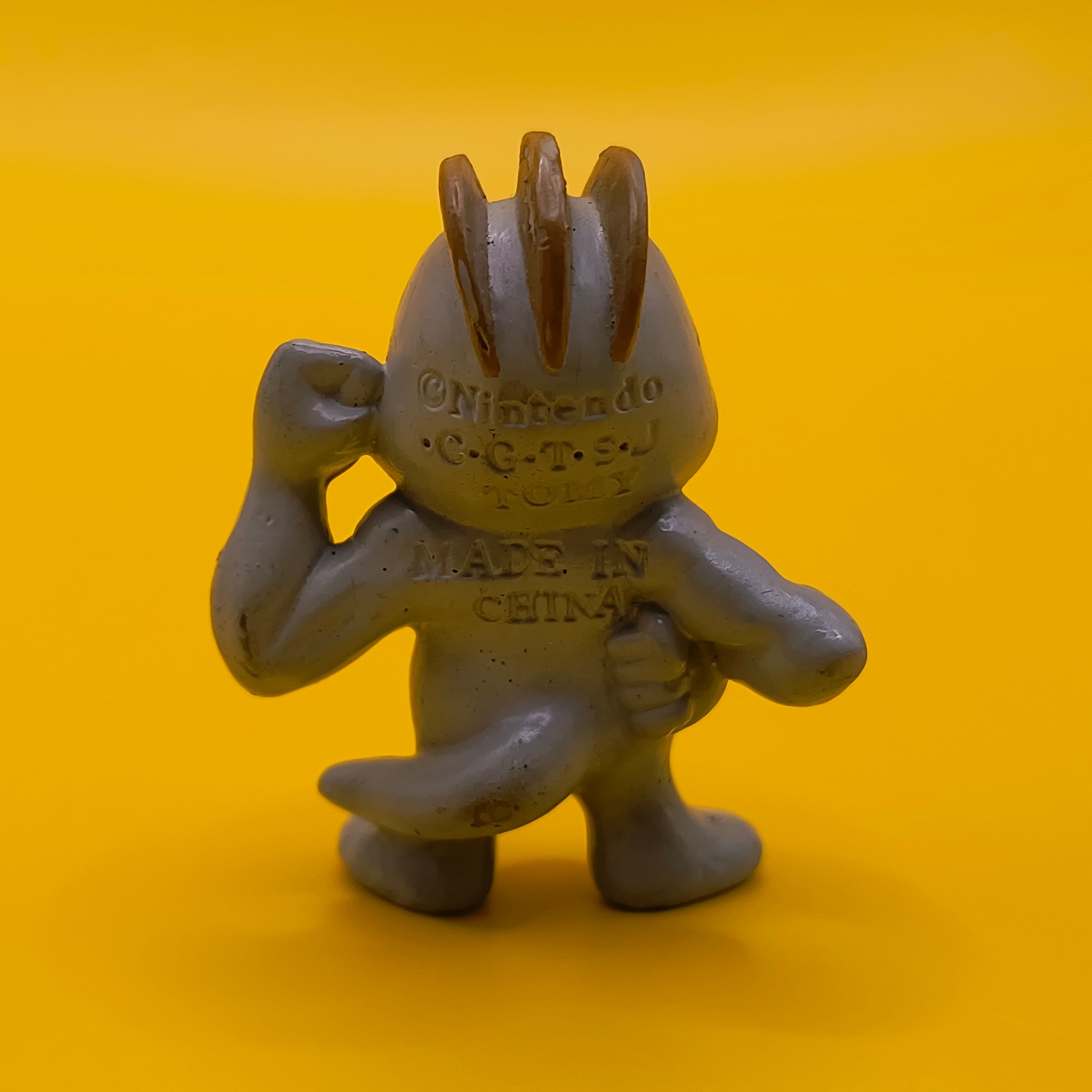 Original 4 cm Machop Pokémon-figur fra Tomy med stempel fra baghovedet til midt ryg.