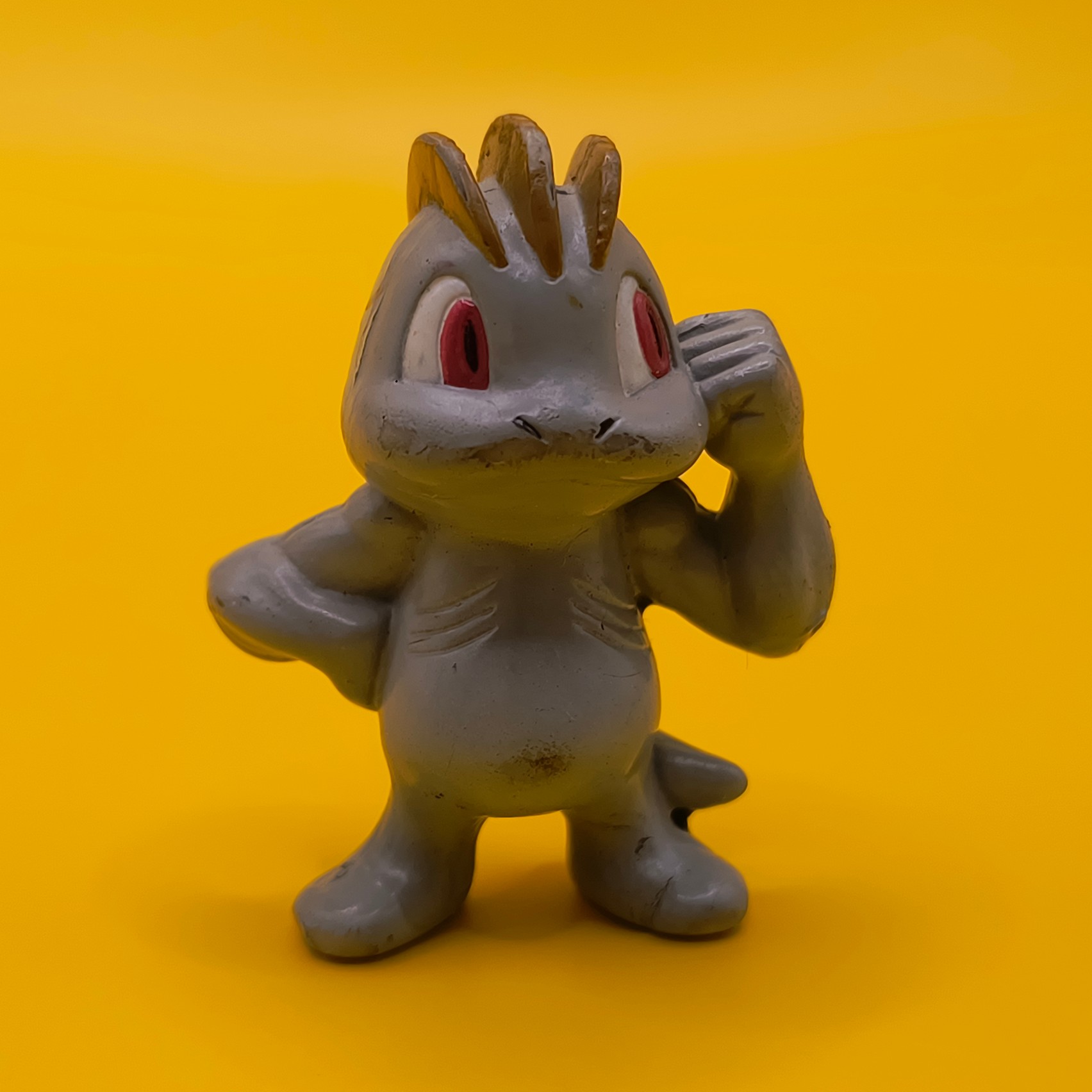Original 4 cm Machop Pokémon-figur fra Tomy med stempel fra baghovedet til midt ryg.