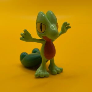Vintage 4,7 cm Treecko Pokémon-figur fra Tomy med stempler placeret under halen.